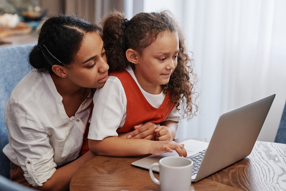 A Mother and Her Daughter Looking at a Laptop